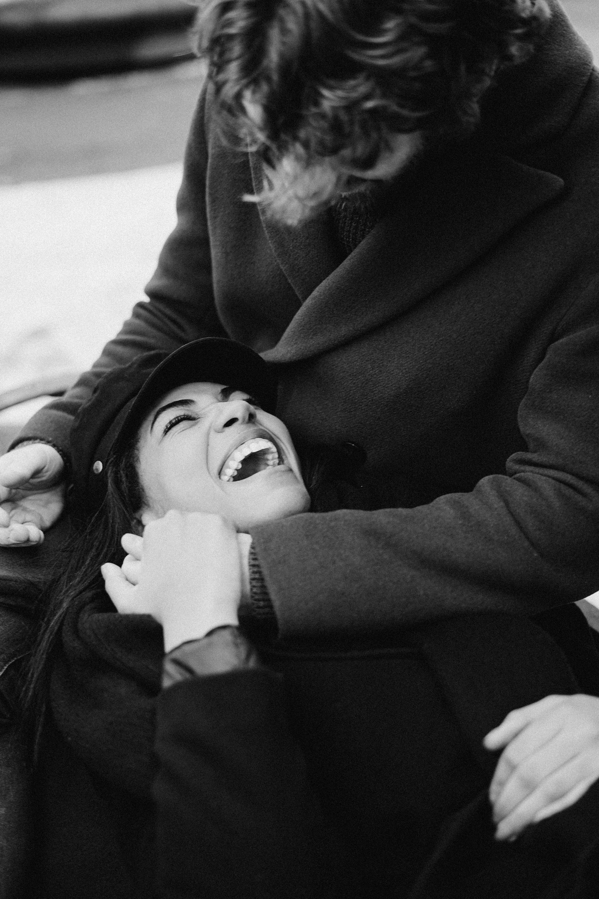 Monochrome Photo of Woman Lying on Man's Lap While Laughing